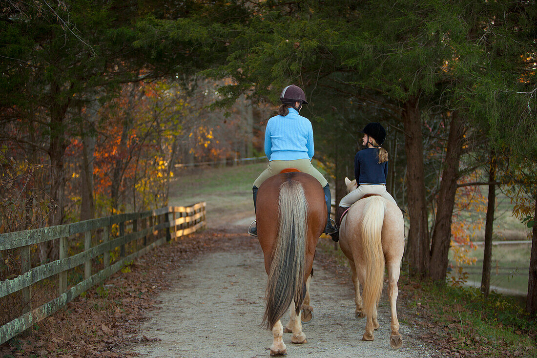 Caucasian girl and trainer riding horses, Manakin, VA, Goochland