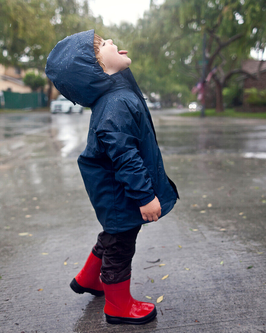 Caucasian boy catching raindrops on tongue, Torrance, California, United States