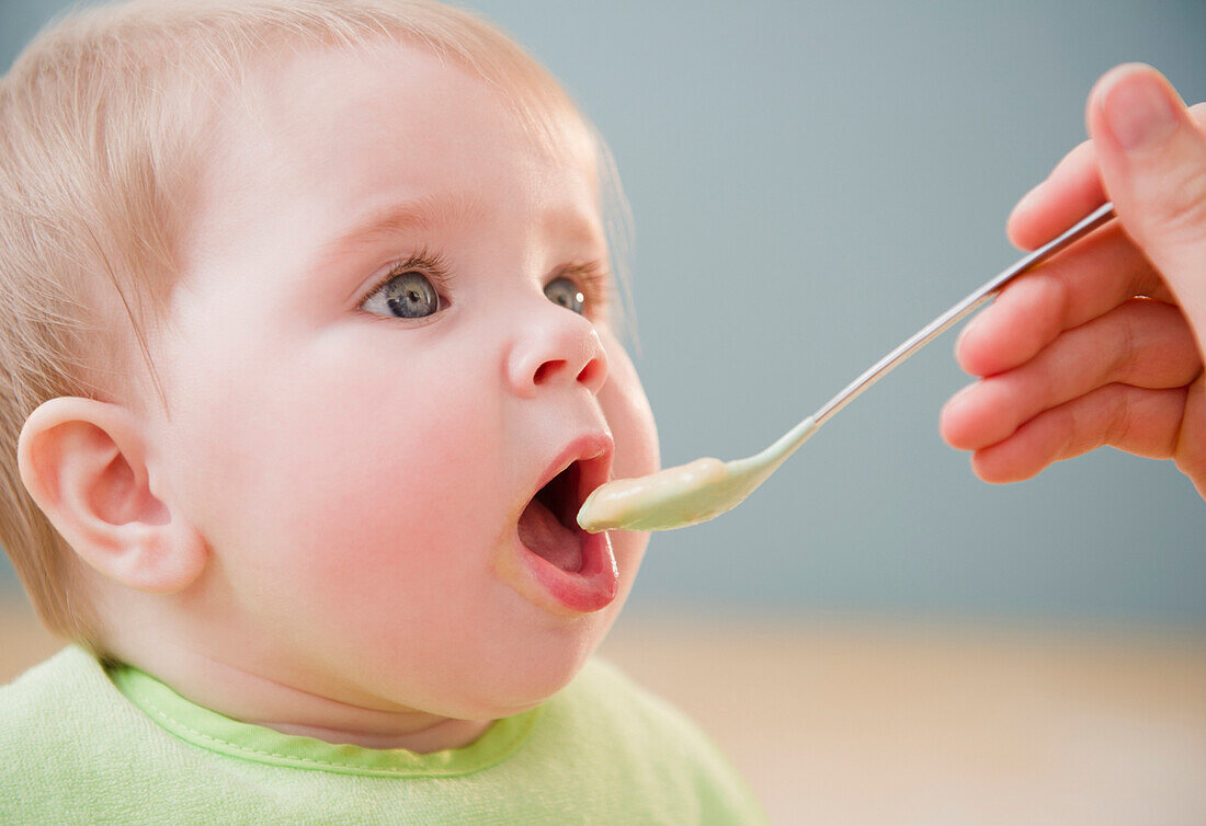 Mother feeding Caucasian baby, Jersey City, New Jersey, United States