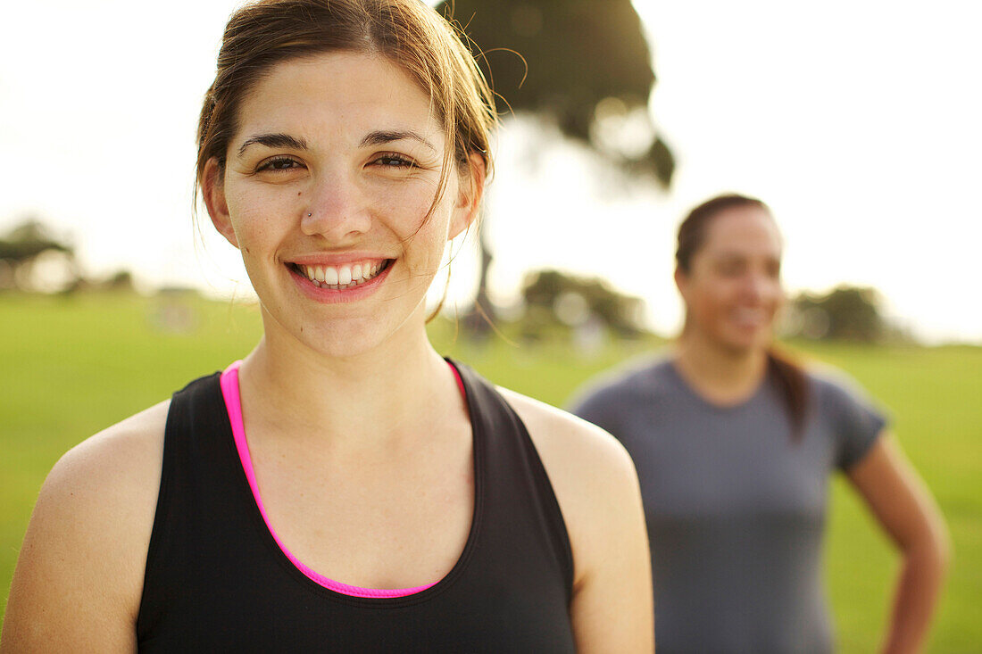 Lächelnde, sportliche Freunde stehen zusammen auf einem Feld, San Diego, Kalifornien, USA