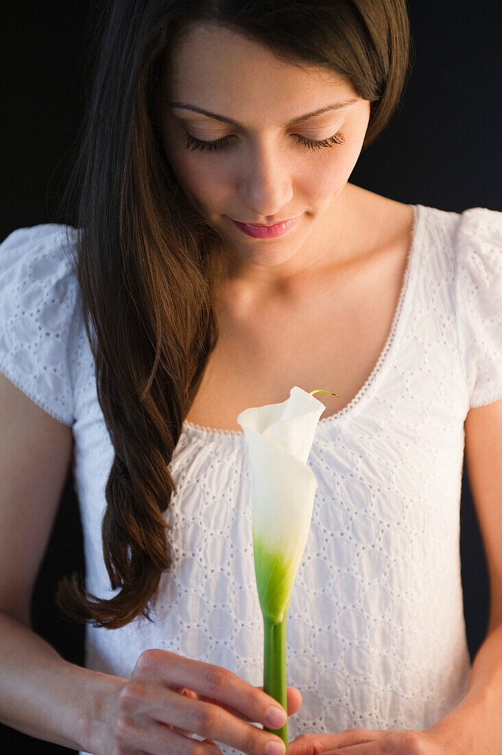 Brazilian woman holding calla lily, Jersey City, New Jersey, United States