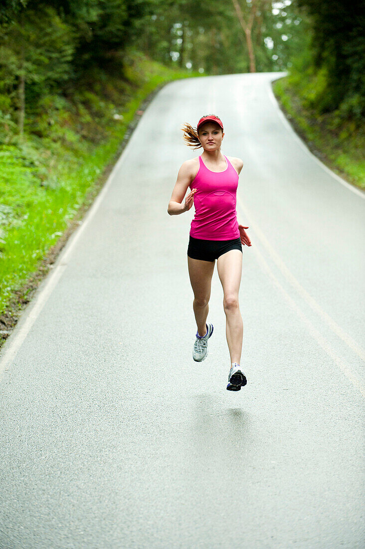 Mixed race woman running on remote road, Bainbridge Island, WA, United States