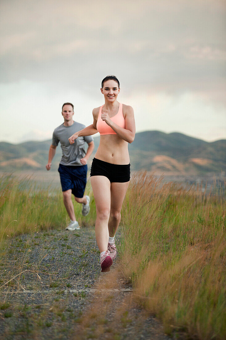 Caucasian couple running together on remote path, South Jordan, Utah, United States