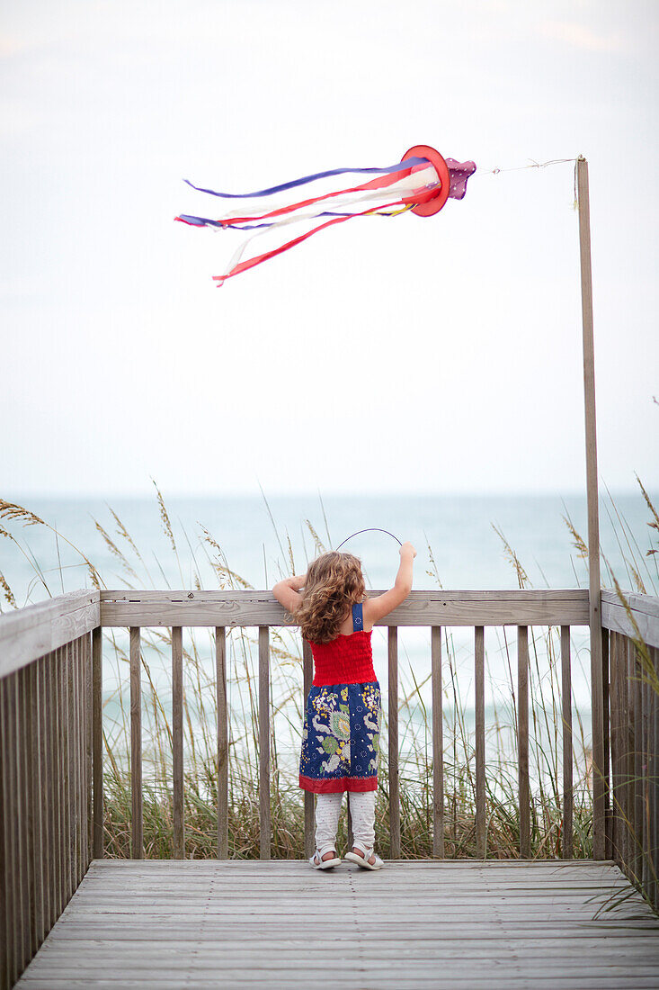 Girl standing on deck near ocean, Topsail Island, North Carolina, USA