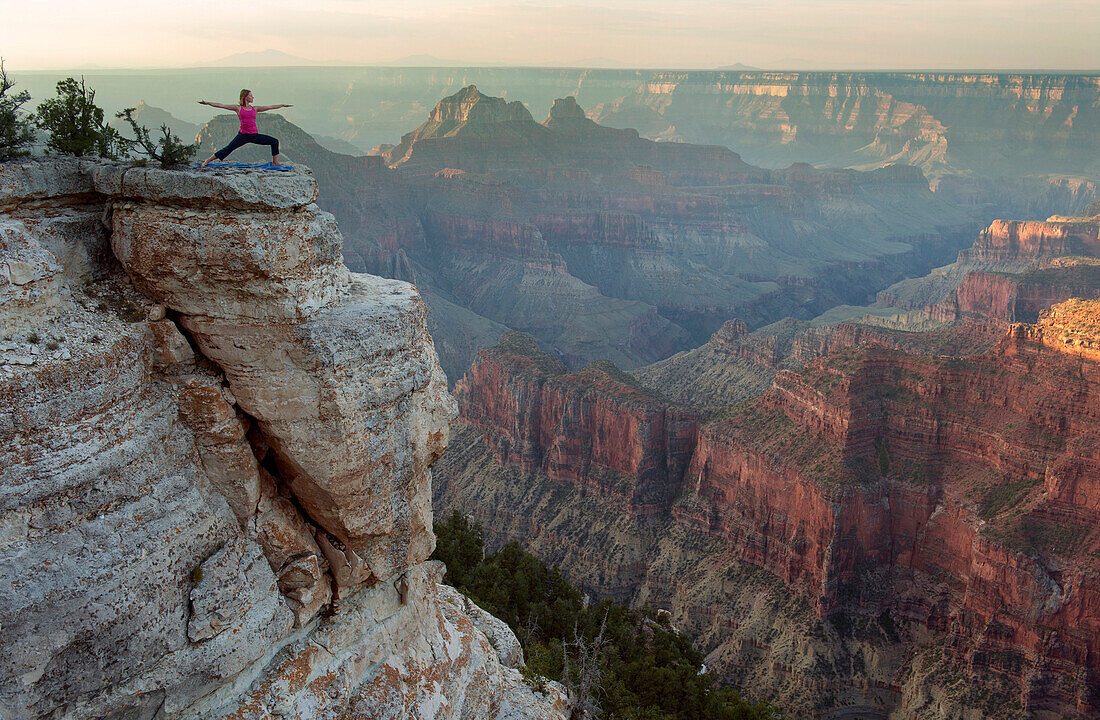 Caucasian woman practicing yoga on cliff near canyon, Grand Canyon, Arizona, United States