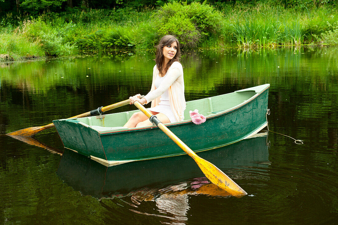 Caucasian woman rowing boat in pond, Bainbridge Island, Wa, USA