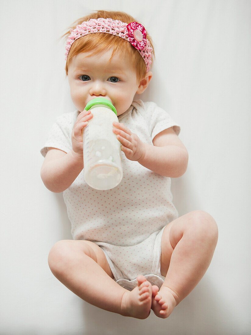 Caucasian baby girl drinking bottle, Lehi, Utah, USA