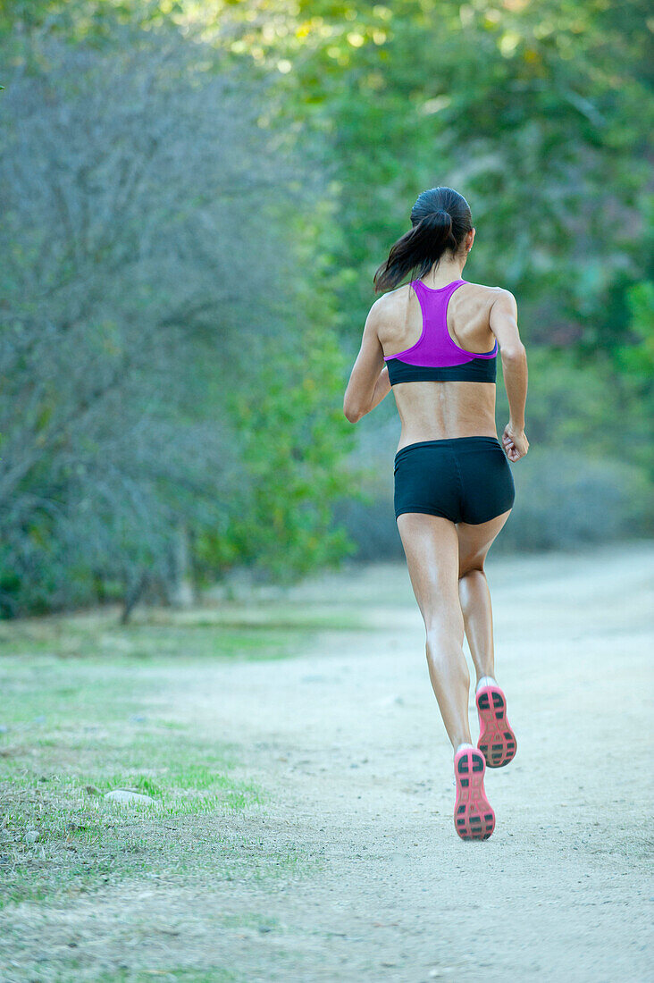 Hispanische Frau, die auf einem abgelegenen Pfad läuft, Los Angeles, Kalifornien, USA