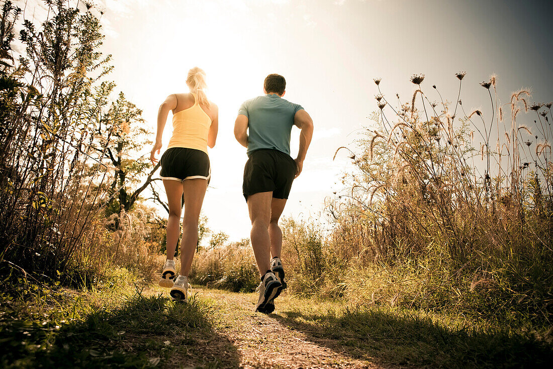 Caucasian couple running together on path, Saint Louis, MO, USA