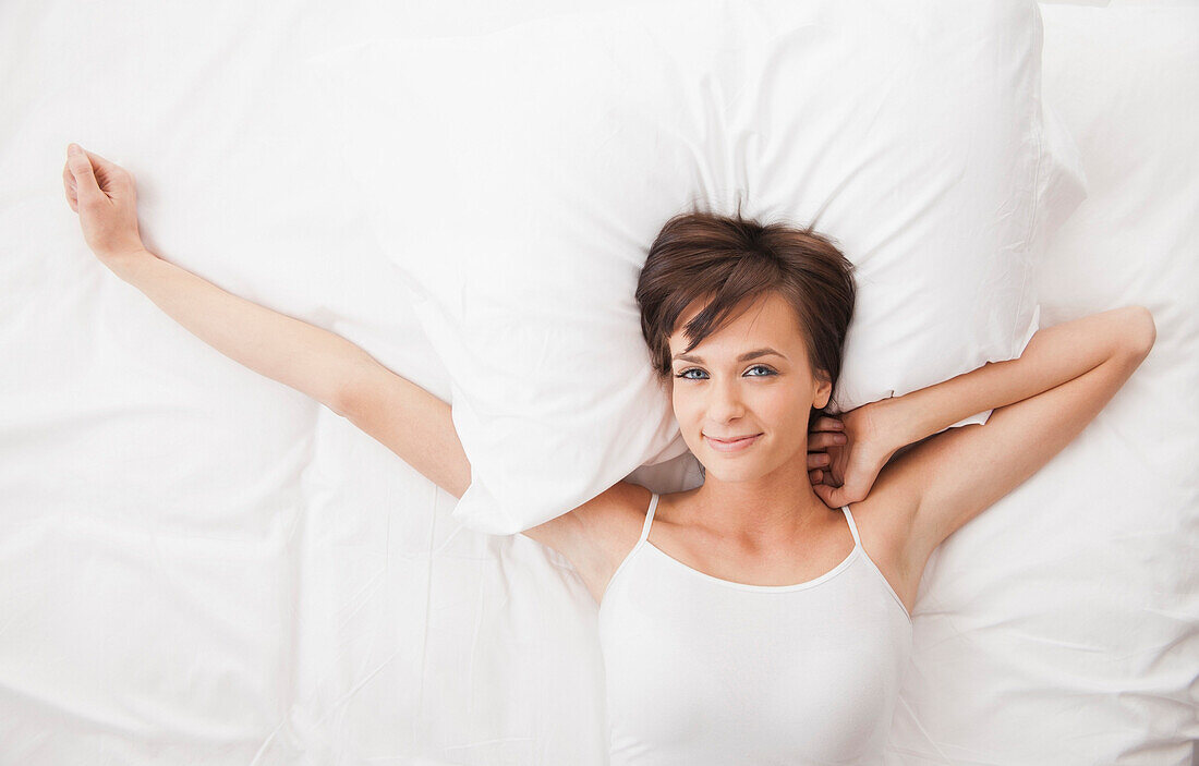 Caucasian woman stretching in bed, Lehi, Utah, USA