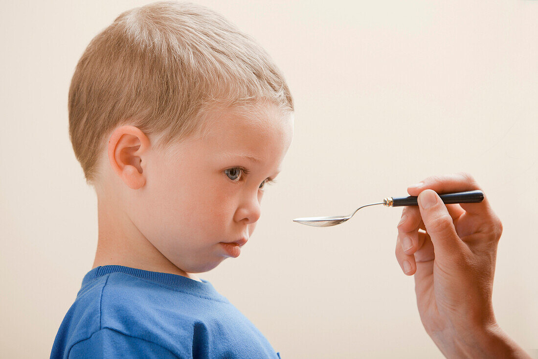 Caucasian boy taking medicine, Lehi, Utah, USA