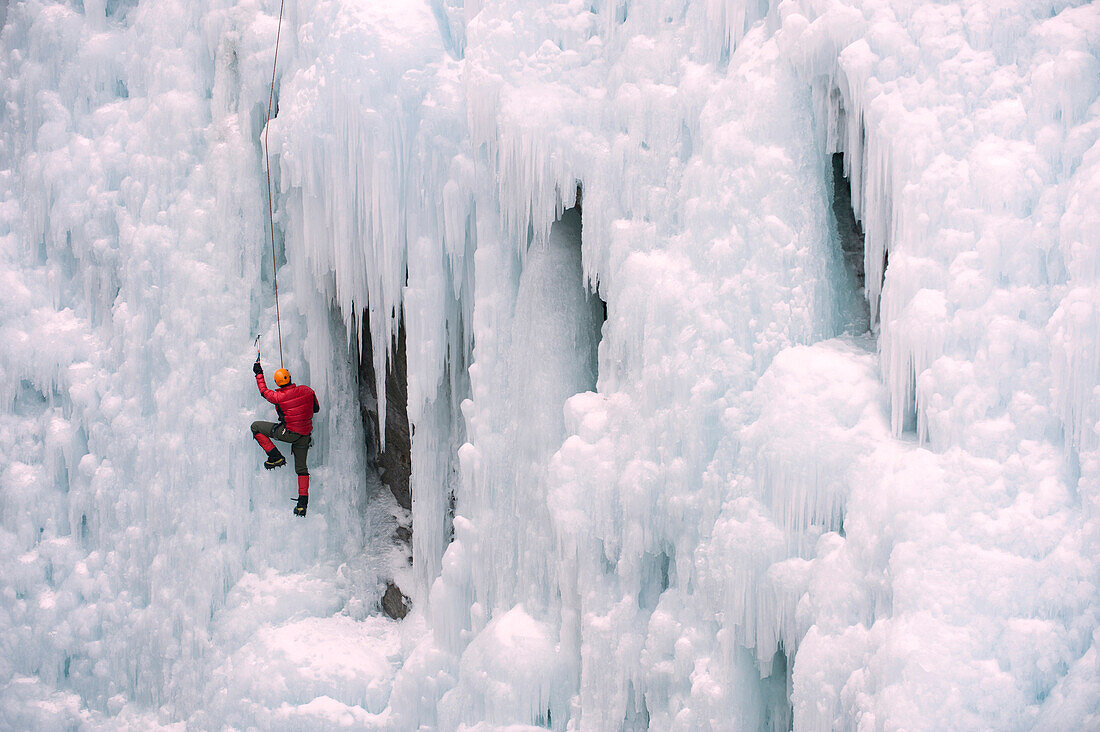 Caucasian man climbing ice wall, Ouray, Colorado, USA
