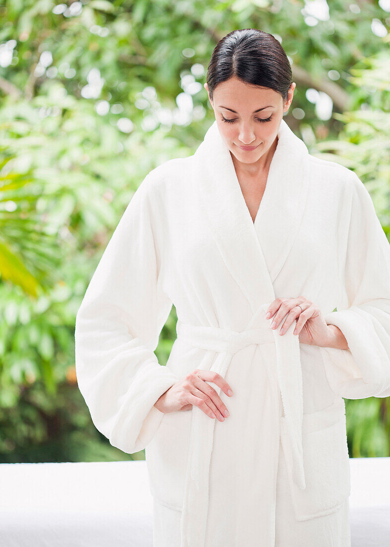 Caucasian woman tying bathrobe, Miami, Florida, United States