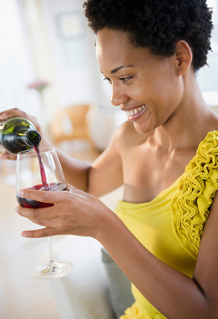 African American woman pouring red wine, Jersey City, New Jersey, USA