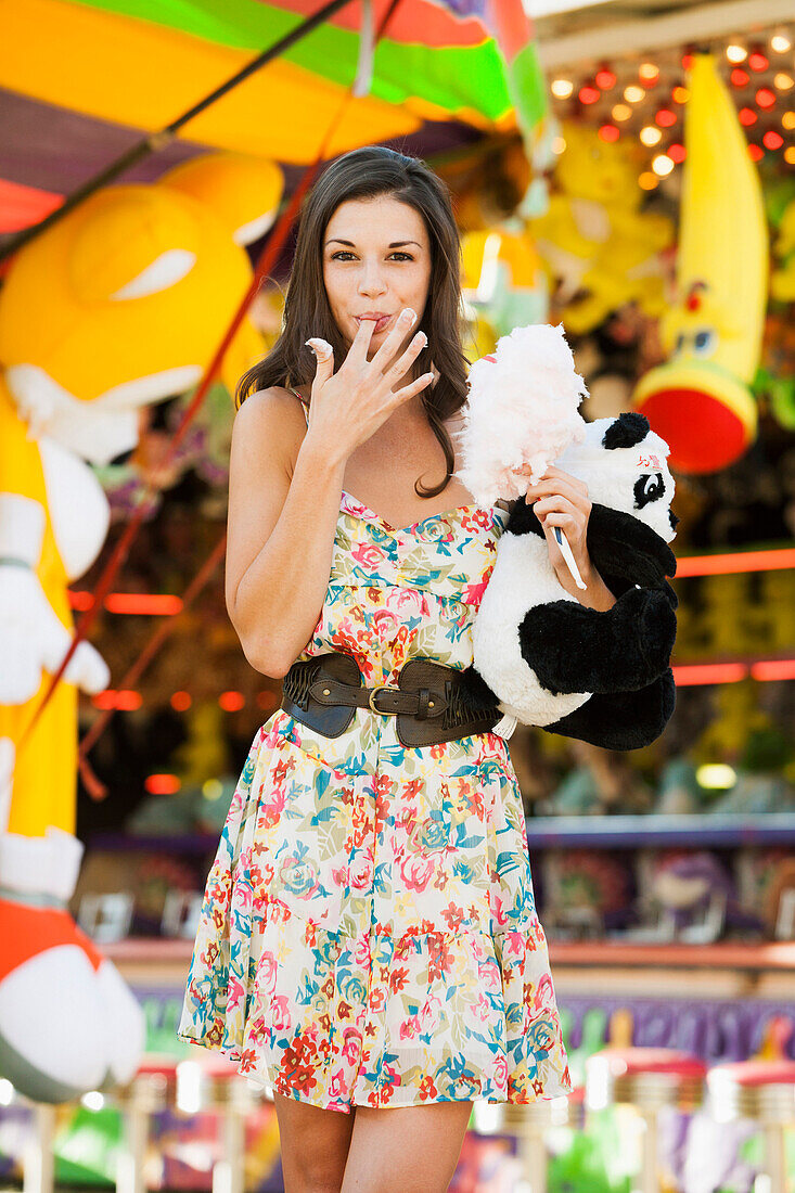 Caucasian woman eating cotton candy at carnival, Salt Lake City, Utah, USA