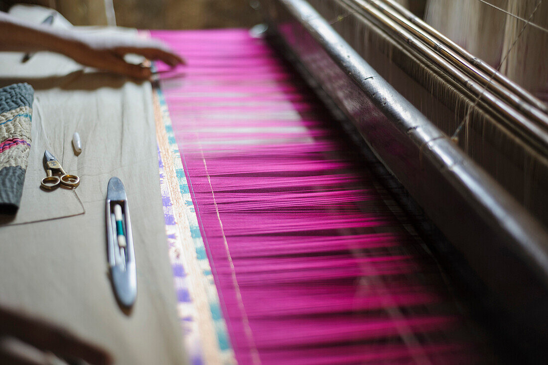 Hand feeling threads in loom, Varanasi, Uttar Pradesh, India