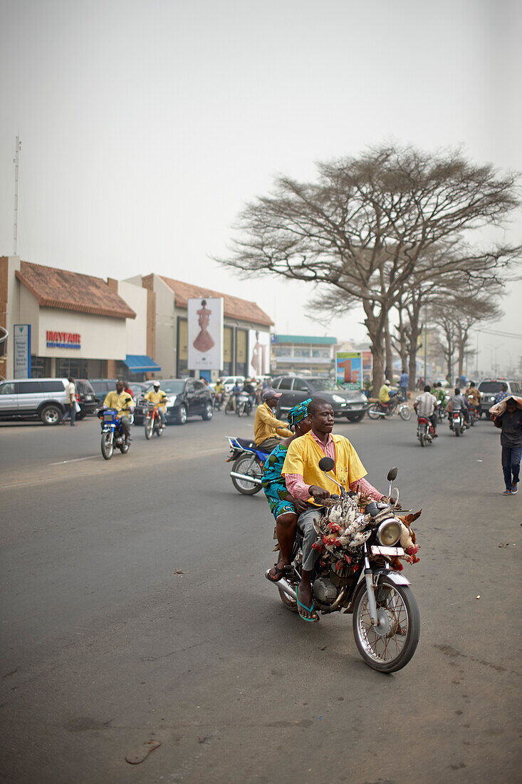 Zemidjans (Motorradtaxi) fährt Marktfrau mit Hühnern zum Ganxi Markt, Ganxi, Cotonou, Benin