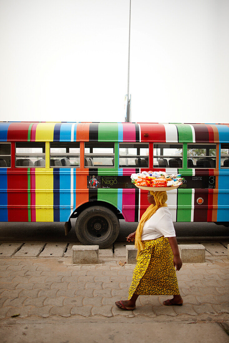 Merchant passing a school bus, Cotonou, Littoral Department, Benin