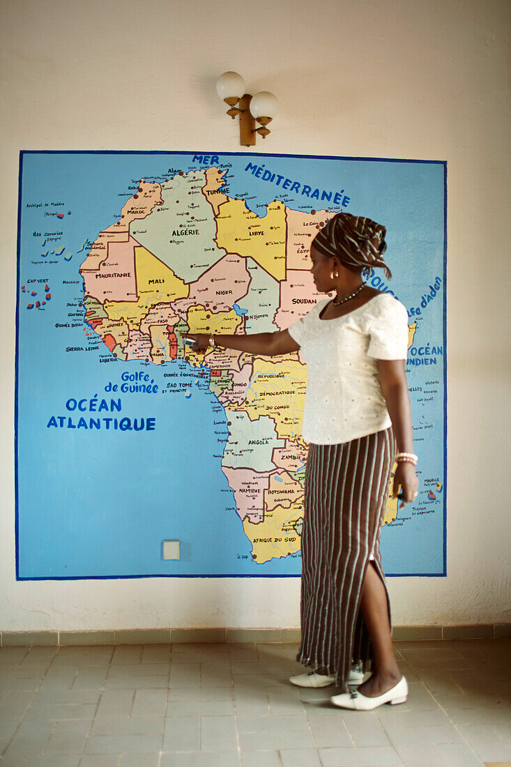 Georgette Singbe zeigt auf eine Landkarte, Villa Karo, Finnisch-afrikanisches Kulturprojekt in altem Hospital, Grand-Popo, Mono, Benin