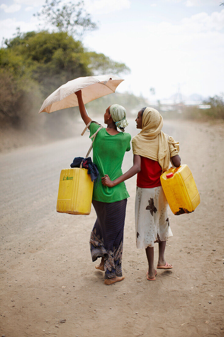 Junge Frauen mit Kanistern auf dem Weg zur Wasserstelle, Adi Ar Kay, Amhara Region, Äthiopien