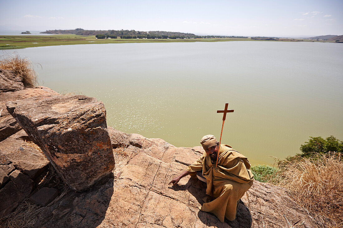 Monk crouching at resting place of Saint Mary, Tana Cherkos monastery island, Lake Tana, Amhara region, Ethiopia