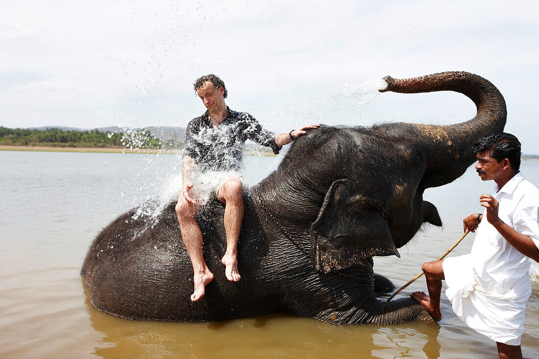 Tourist auf Tempelelefant baden im Kabini Reservoir, Nagarhole-Nationalpark, Karnataka, Indien