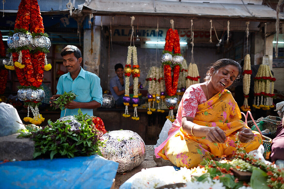 Blumennäher fädeln Blüten auf, Devaraja Markt, Mysore, Karnataka, Indien