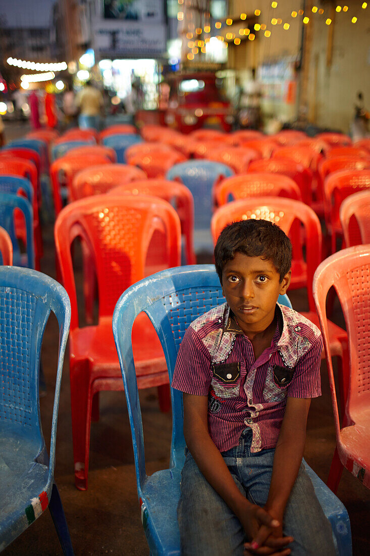 Stühle vor einer Bühne, Junge sitzt im Vordergrund, Stadtteilfest, Mysore, Karnataka, Indien
