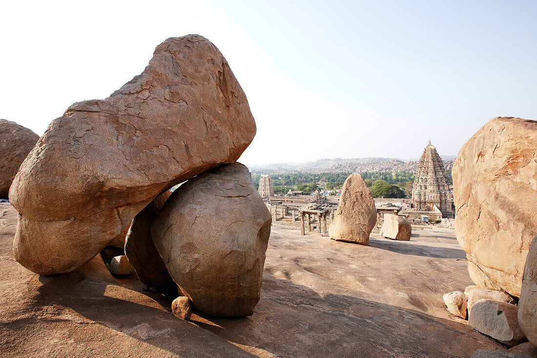Granitfelsen auf Hemakuta Hill, Virupaksha Tempel im Hintergrund, Hampi, Karnataka, Indien