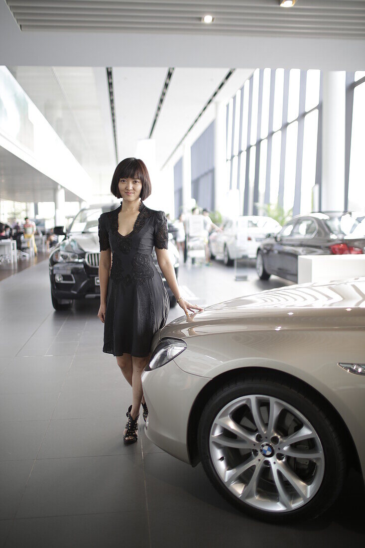 Frau im Showroom von einem BMW Autohändler, Beijing, China