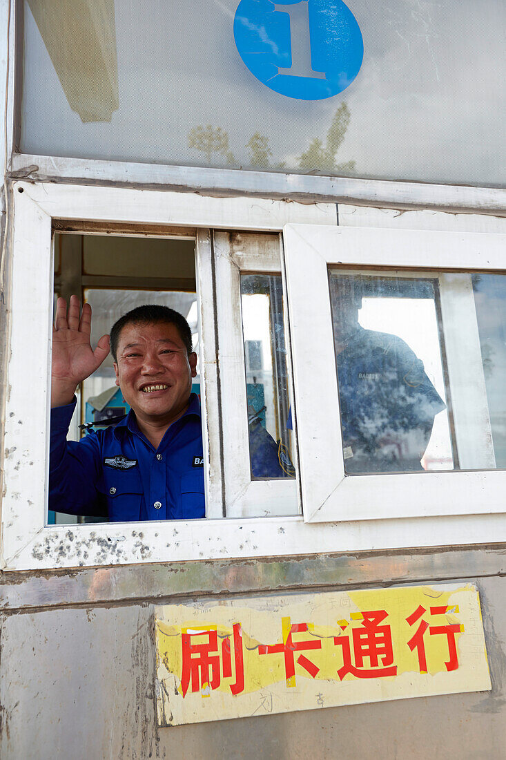 Employee at gate to a container terminal in port of Tianjin, China