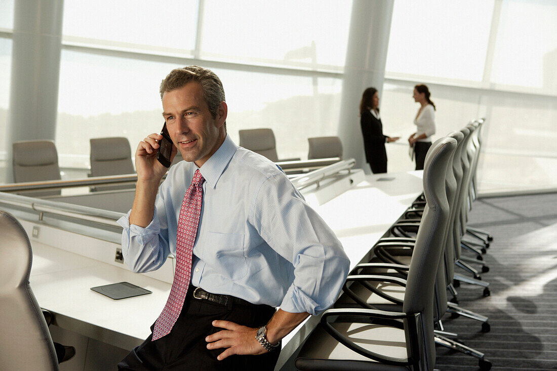 Businessman talking on cell phone in conference room, Virginia Beach