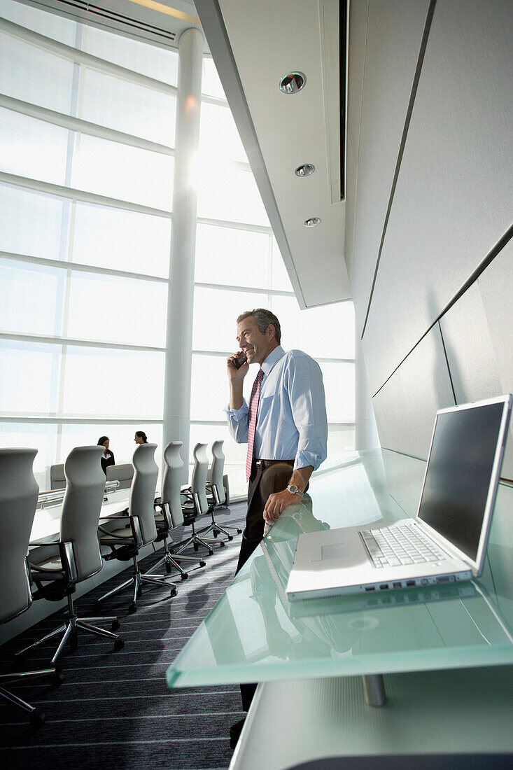 Businessman talking on cell phone in conference room, Virginia Beach