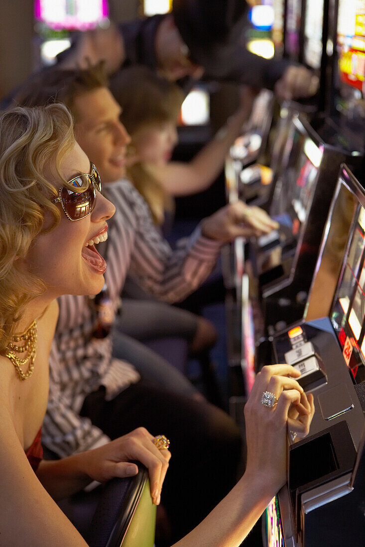 Young woman playing the slot machines in a casino, Vancouver, Canada