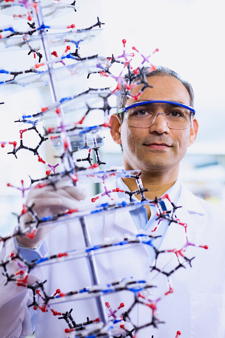 Indian male scientist holding DNA model, Bothell, WA