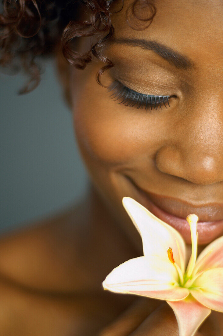 Close up of African woman smelling flower, Austin, TX