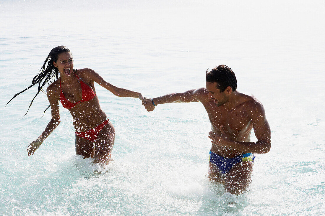 South American couple running in water, Morrocoy, Venezuela