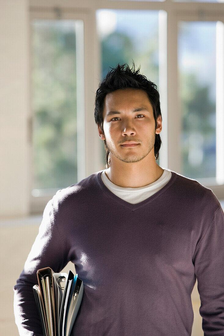 Asian man carrying binders, Cape Town, South Africa