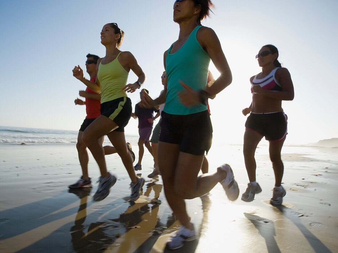 Multi-ethnic runners racing at beach, Newport Beach, CA