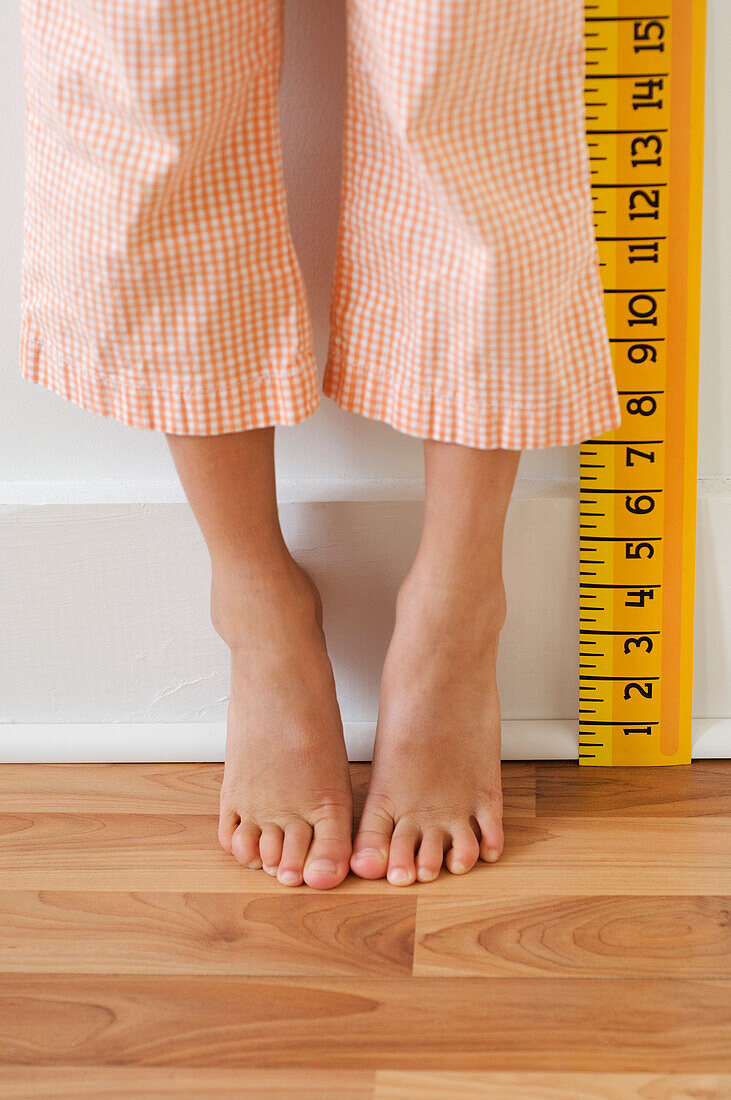 Girl standing on tiptoes next to ruler, Richmond, VA