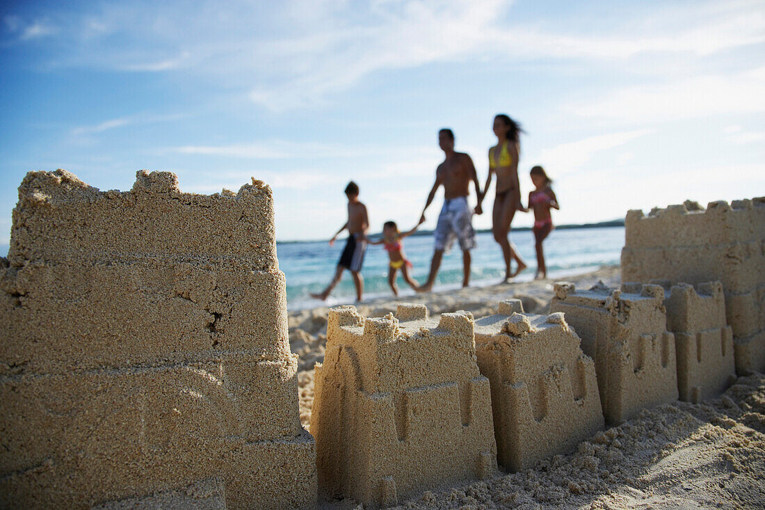 Hispanic family with sand castle in foreground, Morrocoy, Venezuela