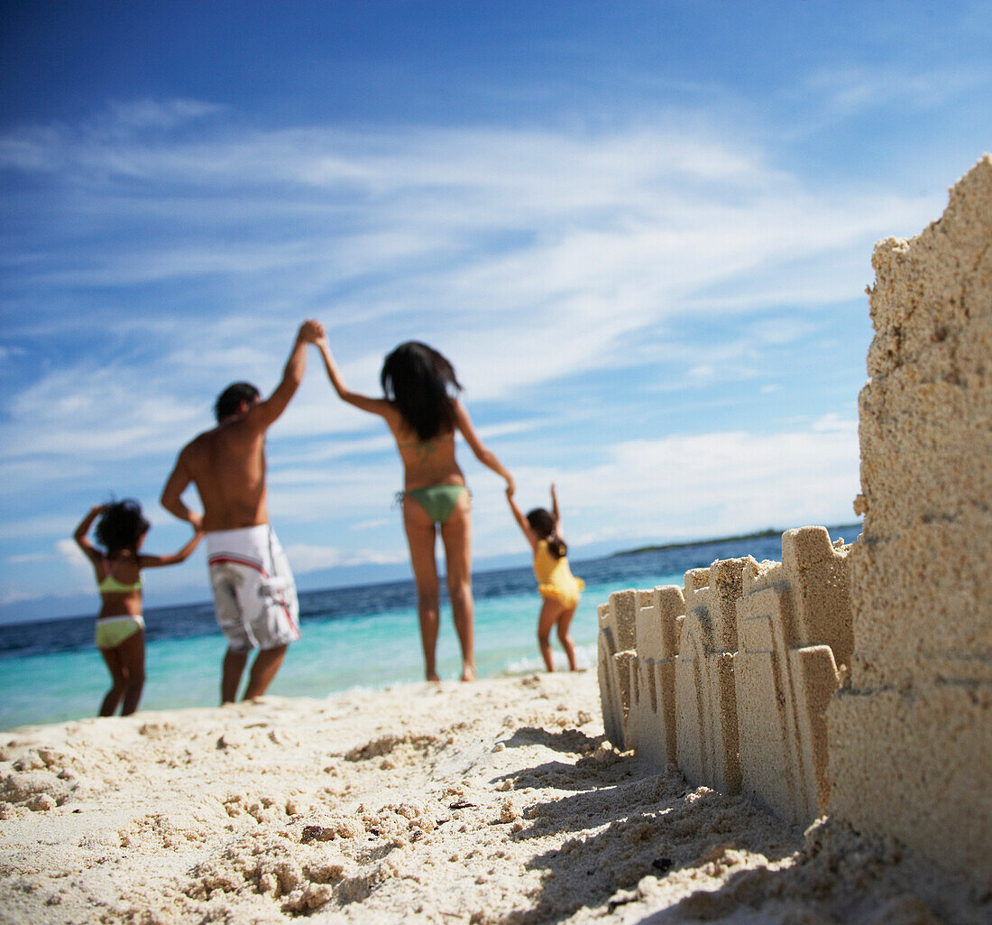 Hispanic family with sand castle in foreground, Morrocoy, Venezuela
