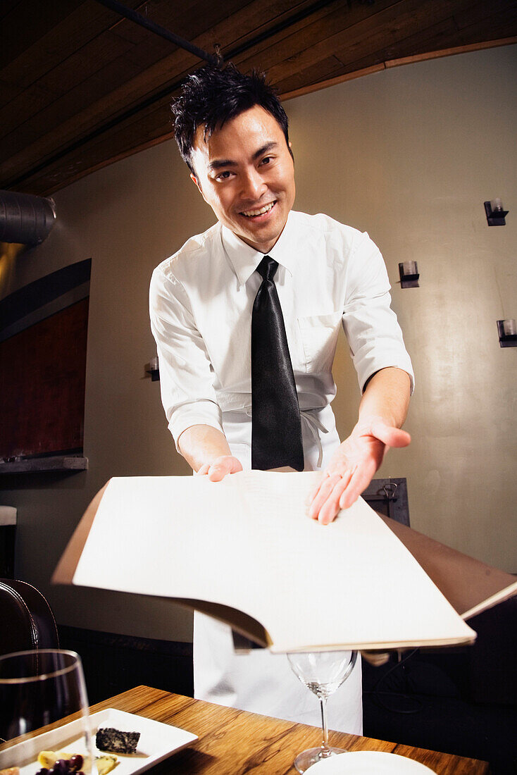 Asian waiter pointing to menu, Seattle, WA