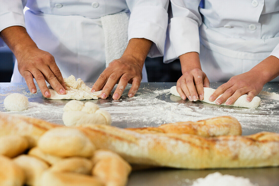 Close up of bakers rolling dough, Orlando, FL