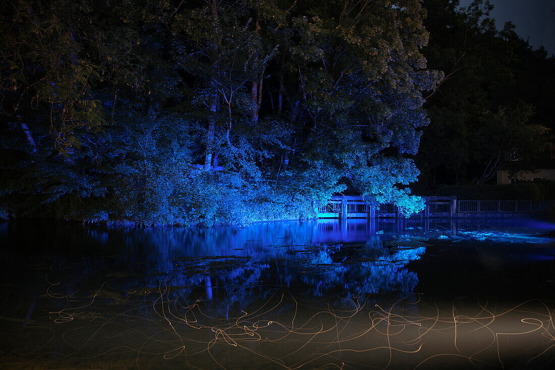 Illumination of Blautopf in the evening, Blaubeuren, Baden-Wuerttemberg, Germany