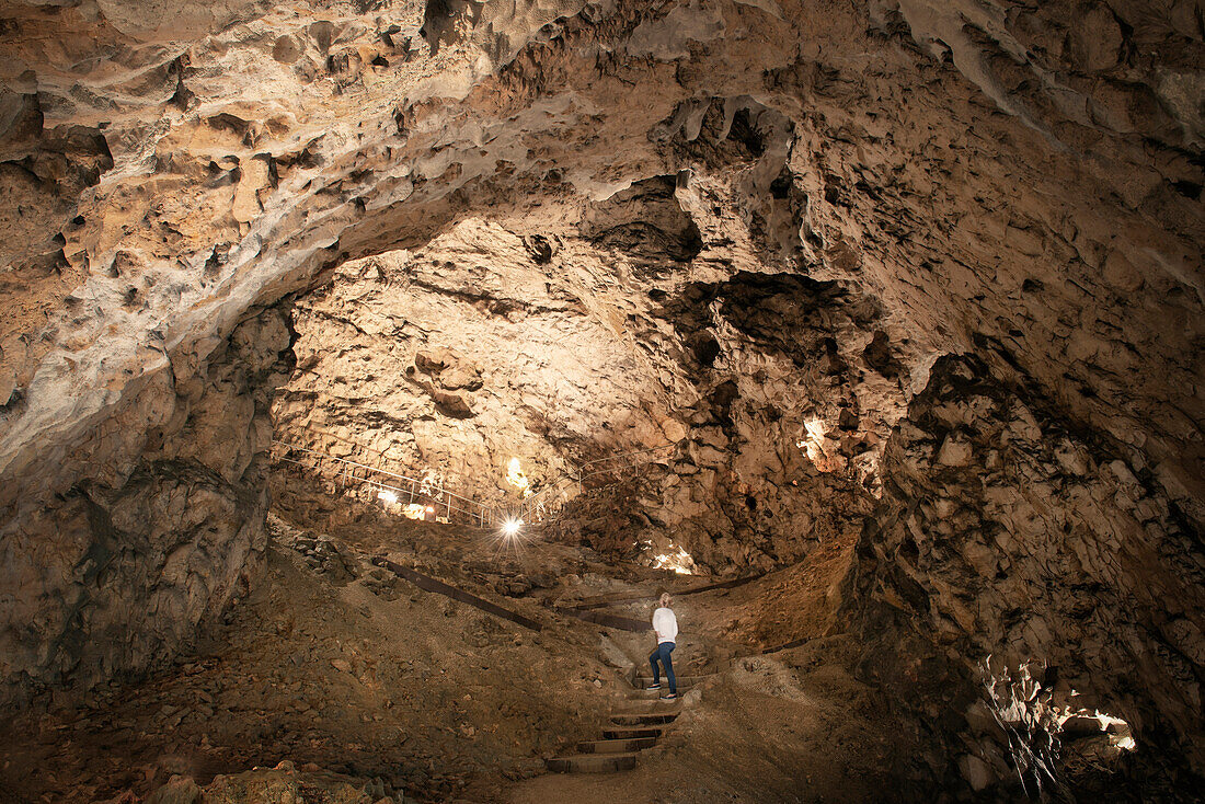 Woman visiting cave Hohle Fels, Swabian Alps, Baden-Wuerttemberg, Germany