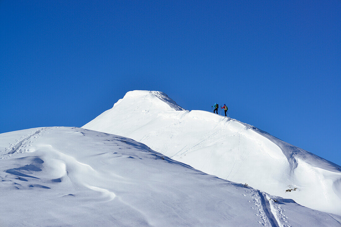 Two female back-country skiers ascending to mount Steinberg, Kitzbuehel Alps, Tyrol, Austria