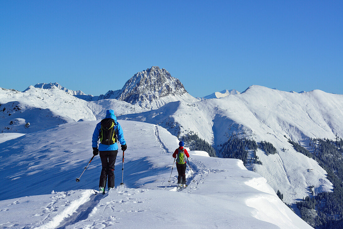 Zwei Frauen auf Skitour fahren vom Steinberg ab, Großer Rettenstein im Hintergrund, Steinberg, Kitzbüheler Alpen, Tirol, Österreich