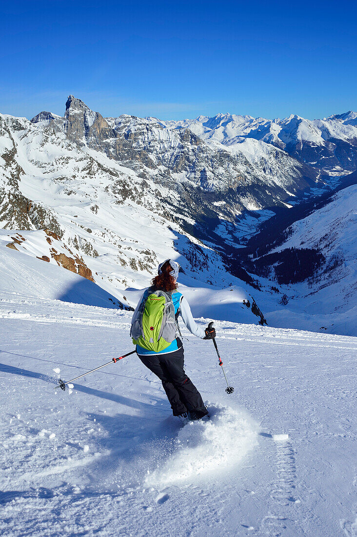 Frau auf Skitour fährt von der Agglsspitze ab, Tribulaun und Zillertaler Alpen im Hintergrund, Agglsspitze, Pflerschtal, Stubaier Alpen, Südtirol, Italien