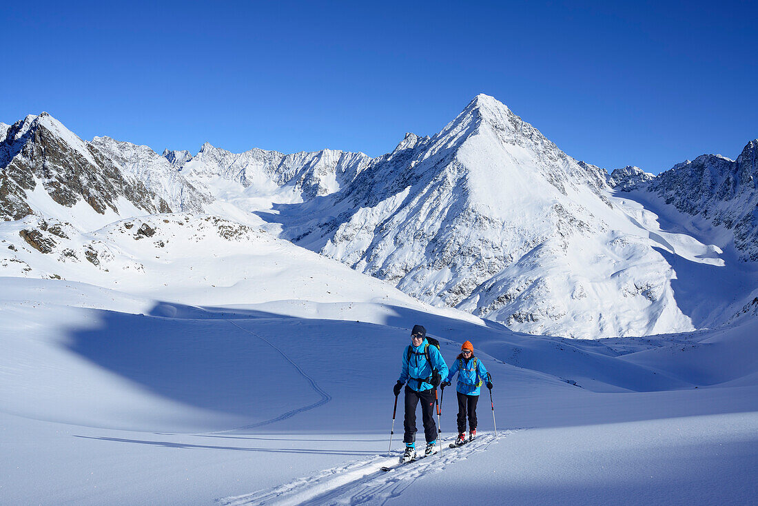 Zwei Frauen auf Skitour steigen zur Kuhscheibe auf, Schrankogel im Hintergrund, Stubaier Alpen, Tirol, Österreich